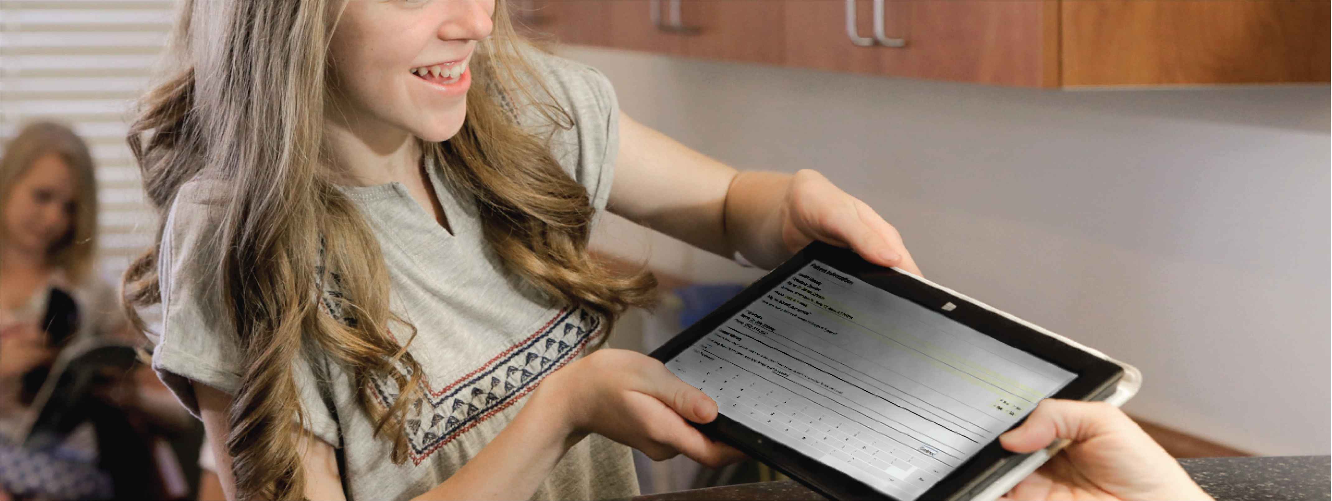 Image of girl using check-in tablet with dental software