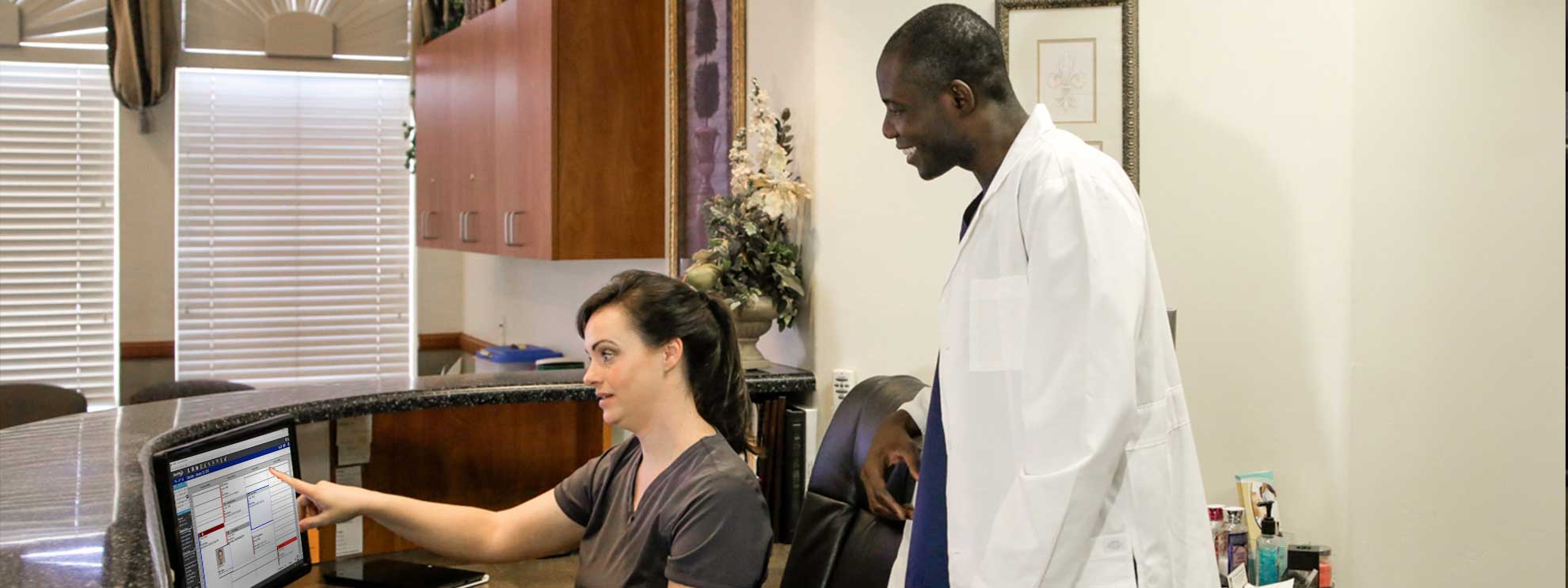 Image of office manager training dentist on dental software